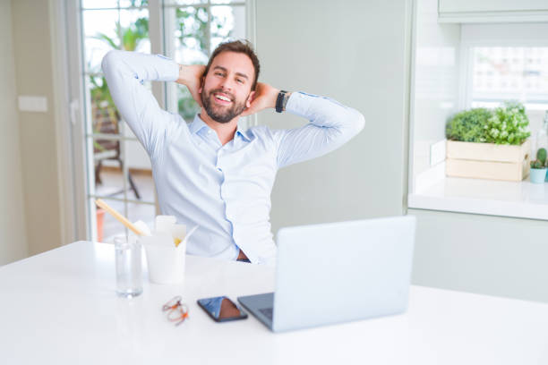 istock Business man eating take away asian noodles food while working using computer laptop and smiling 1134228833