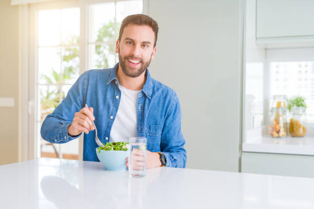 istock Handsome man eating green peas at home 1134228923