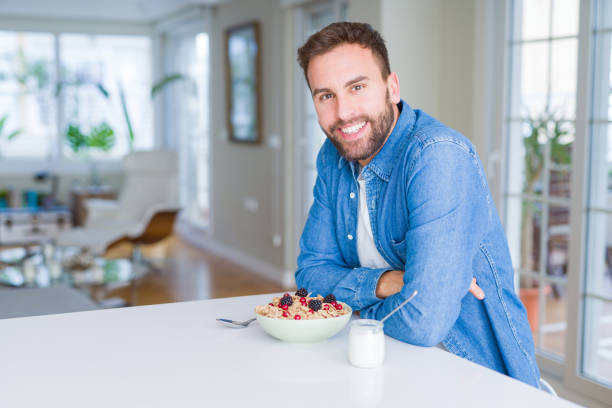 istock Handsome man having breakfast eating cereals at home and smiling 1134228968