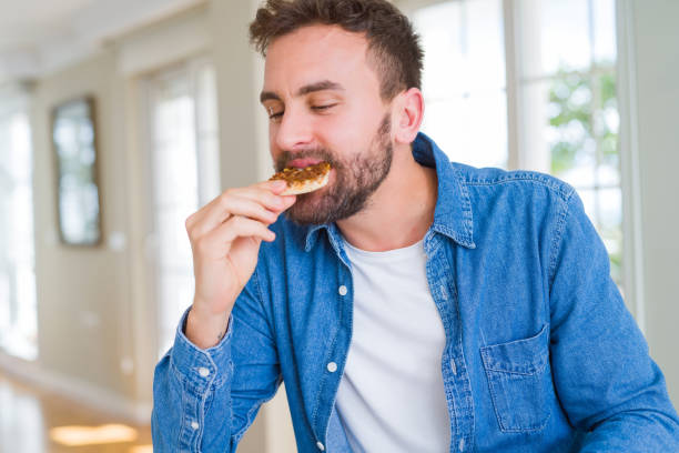 istock Handsome man eating amazing pizza and enjoying at home 1134229085
