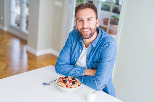 istock Handsome man having breakfast eating cereals at home and smiling 1134229205