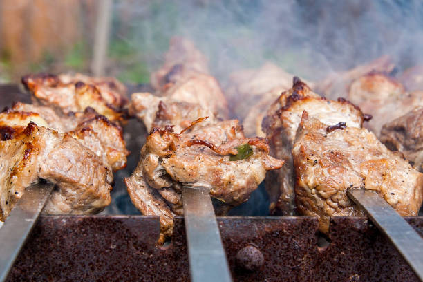 istock Traditional eastern dish, shish kebab. Roasted meat cooked at barbecue with smoke. 1134230025