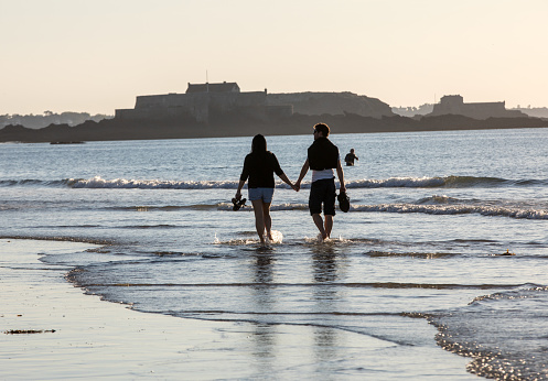 St Malo, France - September 16, 2018: Romantic walk of a couple in love on the beach in Saint Malo. Brittany, France