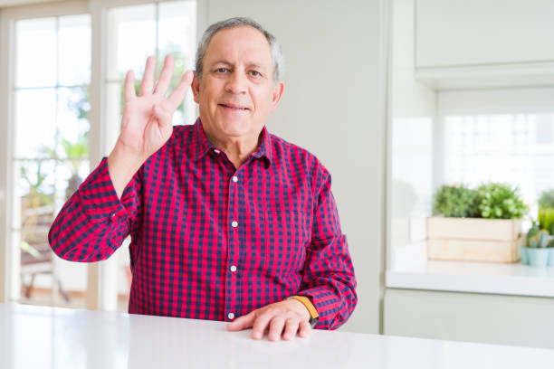 istock Handsome senior man at home showing and pointing up with fingers number four while smiling confident and happy. 1134233268