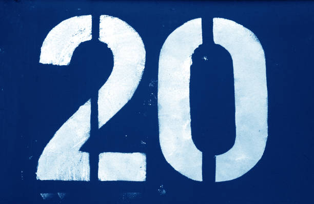 Number 20 in stencil on metal wall in navy blue tone.