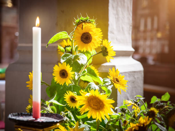 An image of sunflowers with a burning candle in a church
