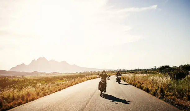 Shot of two young women riding their motorcycles through the countryside