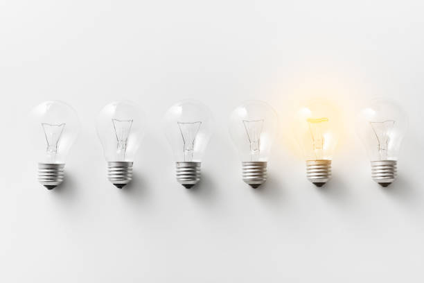 Illuminated light bulb in row of dim ones