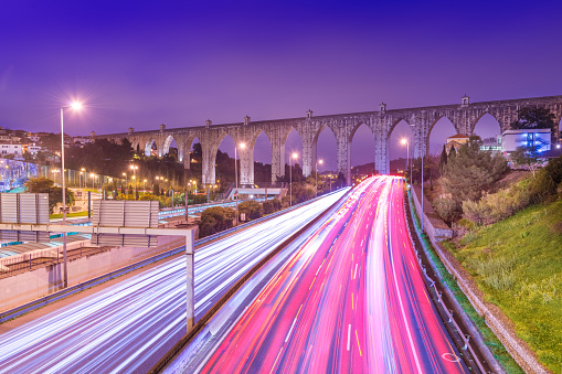 View of highway with car traffic and light trails. The Aguas Livres Aqueduct (Aqueduto das Águas Livres) in Lisbon, Portugal.