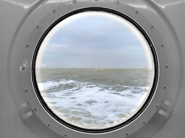 View through a porthole on a stormy sea with waves hitting the ship at the Wadden Sea between Lauwersoog and Schiermmonnikoog