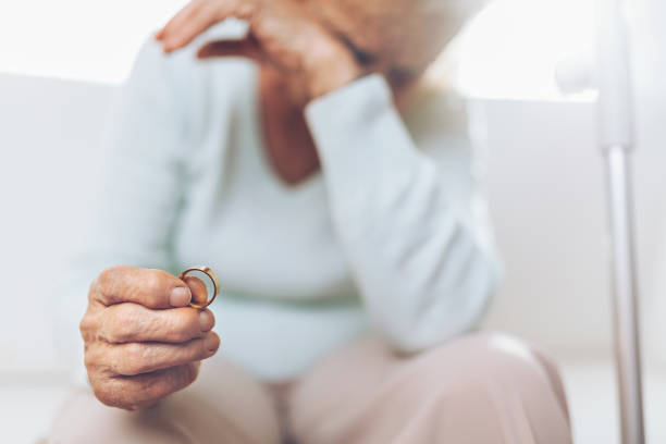 istock Heartbroken elderly woman holding a wedding ring 1134246665