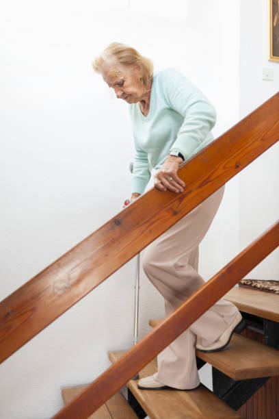istock Elderly woman at home using a cane to get down the stairs 1134247292