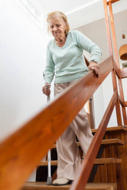 istock Elderly woman at home using a cane to get down the stairs 1134247408