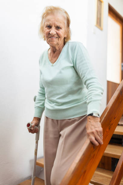 istock Elderly woman at home using a cane to get down the stairs 1134247488