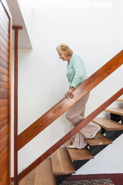 istock Elderly woman at home using a cane to get down the stairs 1134247523