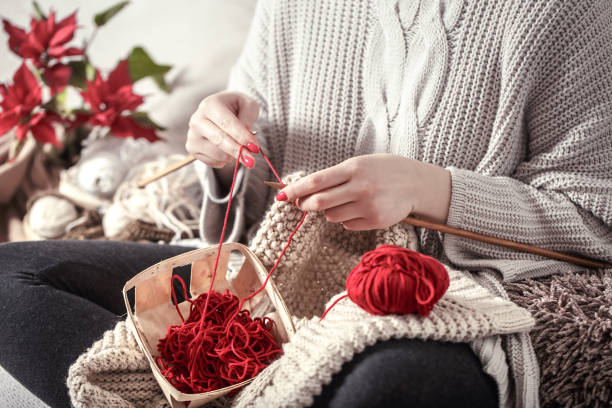 istock woman knits knitting needles on the couch 1134249530