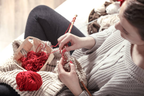 istock woman knits knitting needles on the couch 1134249540