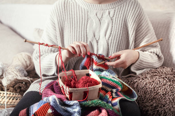istock woman knits knitting needles on the couch 1134249542