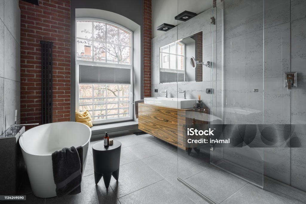 Industrial style bathroom Industrial style bathroom with oval bathtub and walk in shower Bathroom Stock Photo