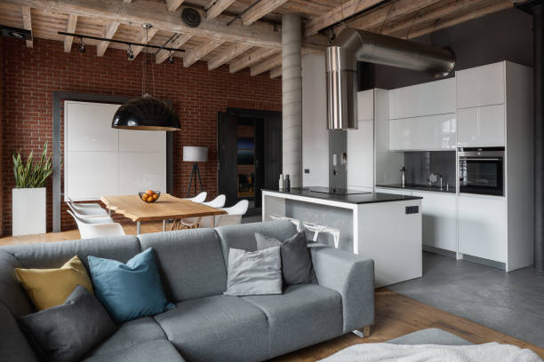 Apartment with gray sofa Industrial style apartment with gray corner sofa, dining table and open kitchen industrial style photos stock pictures, royalty-free photos & images