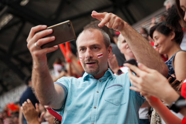 homem que toma um selfie em um fósforo footbal - red white american football stadium soccer stadium - fotografias e filmes do acervo