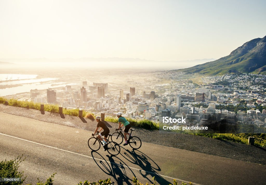 It’s all about the journey Shot of two sporty young women out cycling on a country road Cycling Stock Photo