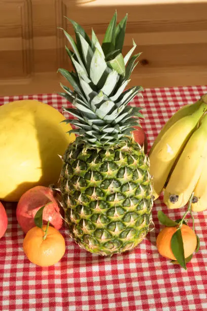 A pineapple and various fruits on a kitchen table