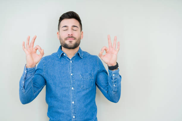 istock Young handsome man over isolated background relax and smiling with eyes closed doing meditation gesture with fingers. Yoga concept. 1134252925