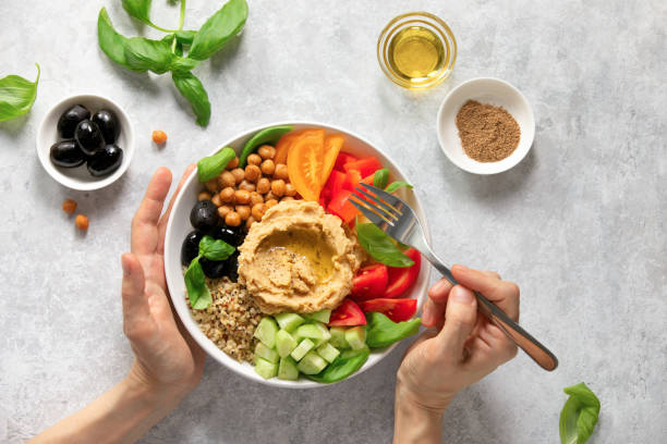 Mediterranean Buddha bowl with hummus Vegetarian Buddha bowl with hummus, olives and quinoa, view from above salad bowl photos stock pictures, royalty-free photos & images
