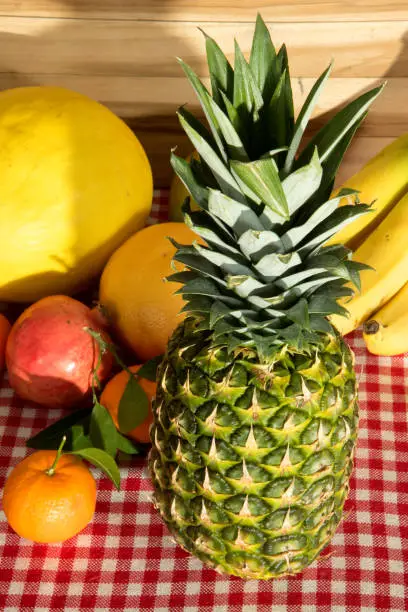 A pineapple and other, fresh fruits