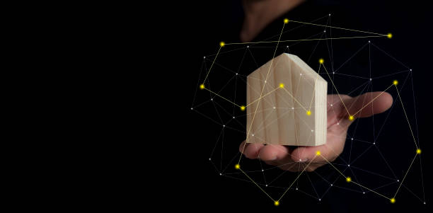 istock Man hold house toy on black background with copy space. 1134257982
