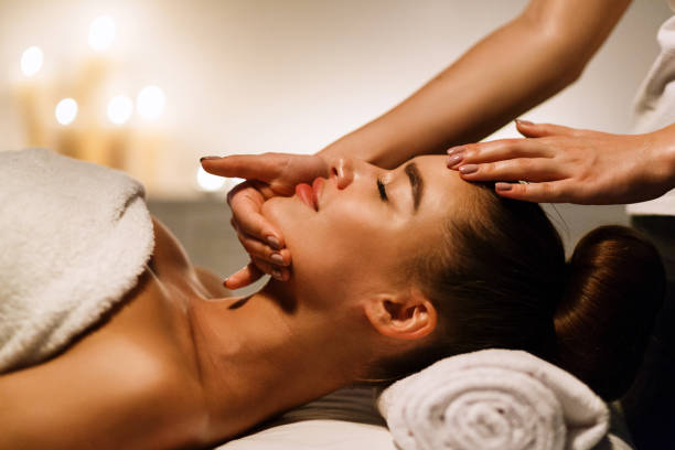 woman enjoying anti aging facial massage in atmospheric spa - rebellion aging process facial mask beauty treatment imagens e fotografias de stock