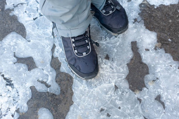 istock Child steps on frozen puddle with thin ice 1134261913