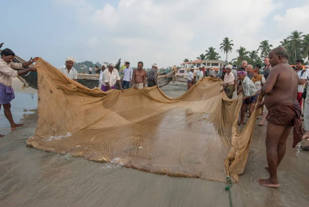 Kovalam, India - February 20th, 2010: Unidentified fishermen pull out empty seine in Kovalam, Kerala, India. Fishery resources of coastal waters in Kerala have significantly decreased.