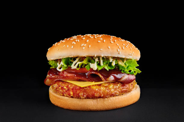 hamburguesa perfecta con chulet, queso, tocino, tomate, lechuga aislada en fondo negro - food elegance cutlet restaurant fotografías e imágenes de stock