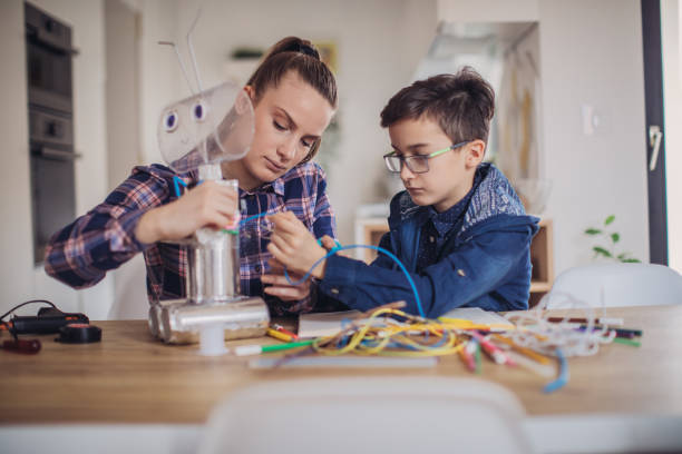 istock Big sister and little brother making a robot for school science project 1134267317