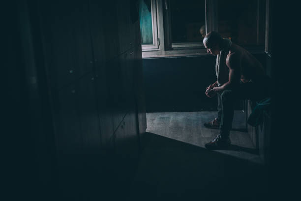 istock Fit body builder sitting in dark locker room in gym 1134269912