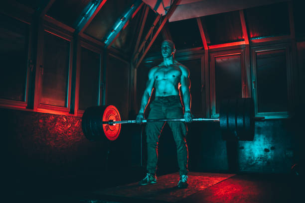 istock Fit man weightlifting in dark gym 1134270121
