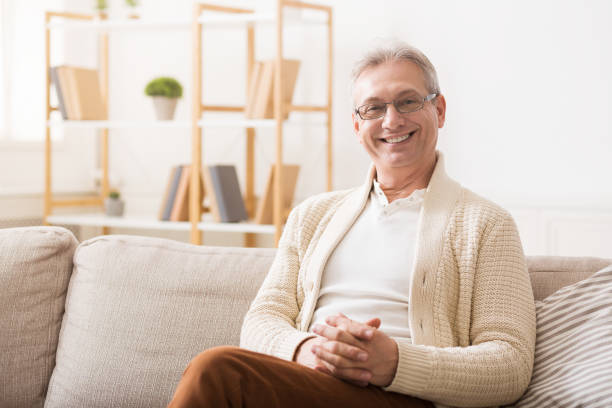 istock Happy senior man resting on sofa and looking at camera 1134270189
