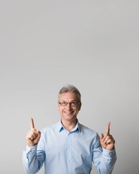 istock Happy mature man pointing up at copy space 1134270193