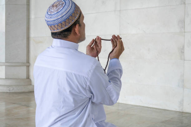 istock Rear View Of Man Praying In Mosque 1134273502