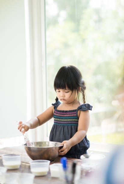 istock Asian little girl cooking something in kitchen 1134274915