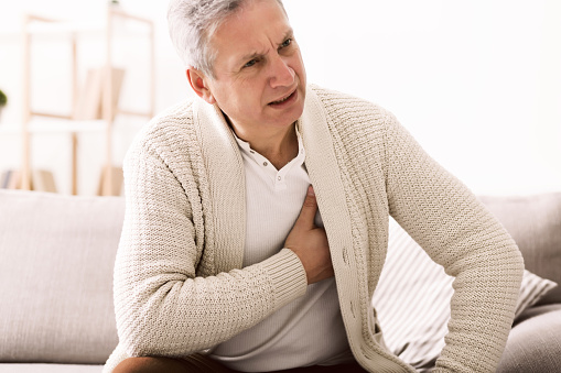 Mature man with chest pain, suffering from heart attack at home