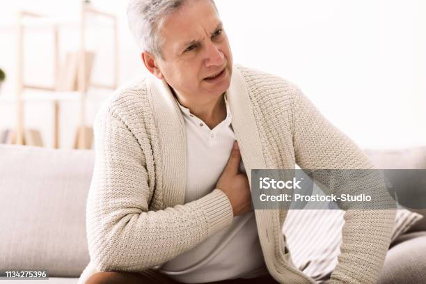 Mature Man With Chest Pain Suffering From Heart Attack Stock Photo - Download Image Now