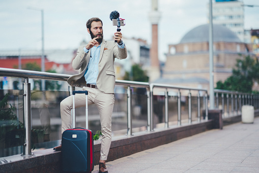 Mid adult businessman vlogging in the city