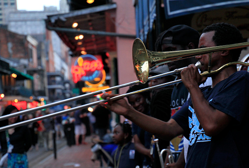 12 April 2018 - New Orleans, Louisiana / United States: Jazz musicians performing in the French Quarter of New Orleans, Louisiana, with crowds and neon lights in the background.