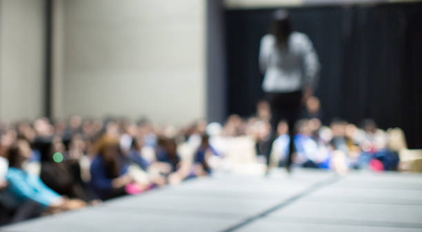 Blurred Female Speaker and Audience