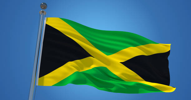 istock Jamaica flag in the wind against clear blue sky, 3d illustration 1134277683