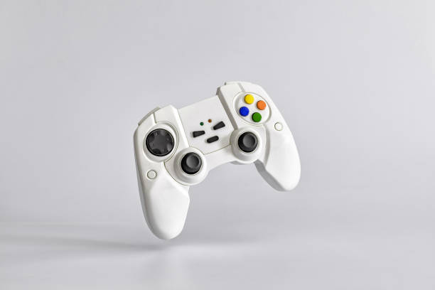 weißes gamepad auf weißem uniform-hintergrund. minimalismus. kopierraum für text - joypads stock-fotos und bilder