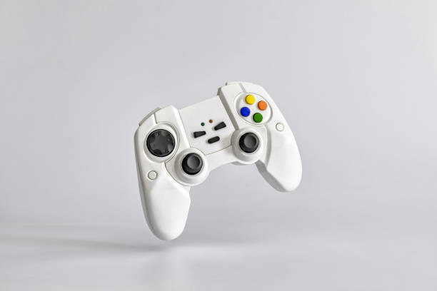 gamepad blanco sobre fondo blanco uniforme. minimalismo. copiar espacio para texto - videojuego fotos fotografías e imágenes de stock